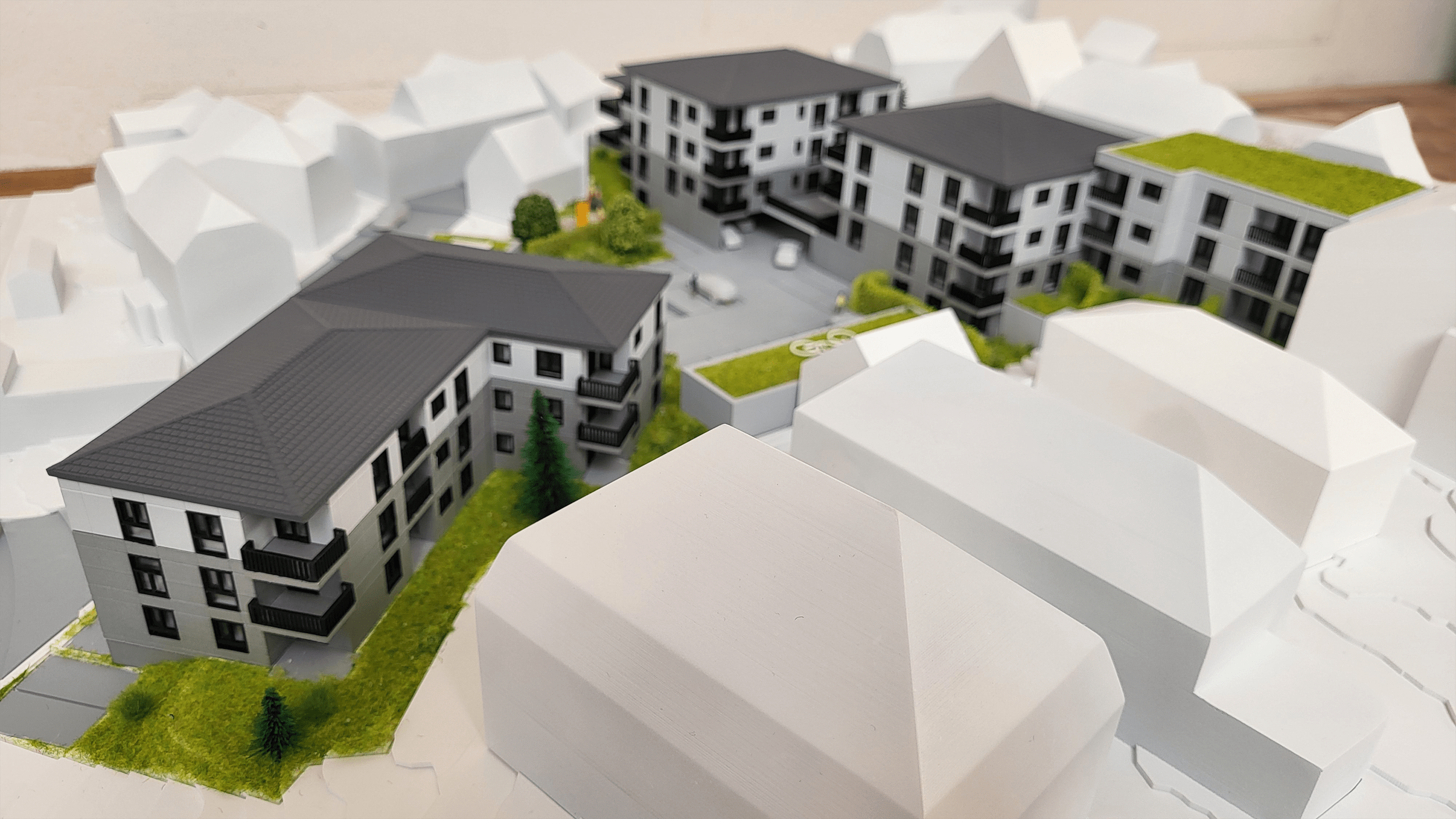 Frontalansicht des präzise gefertigten Architekturmodells einer Wohnanlage in Bayern, die Fassadengestaltung und Eingangsbereiche hervorhebend.