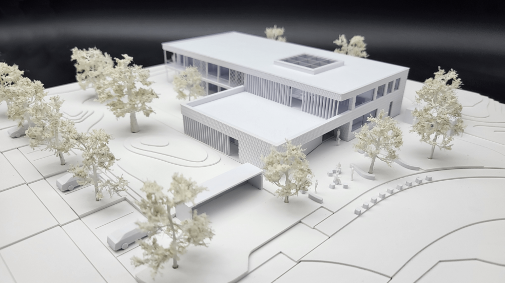 Detailgetreues Architekturmodell einer modernen Villa mit Grünanlagen, Bäumen und Parkplätzen.