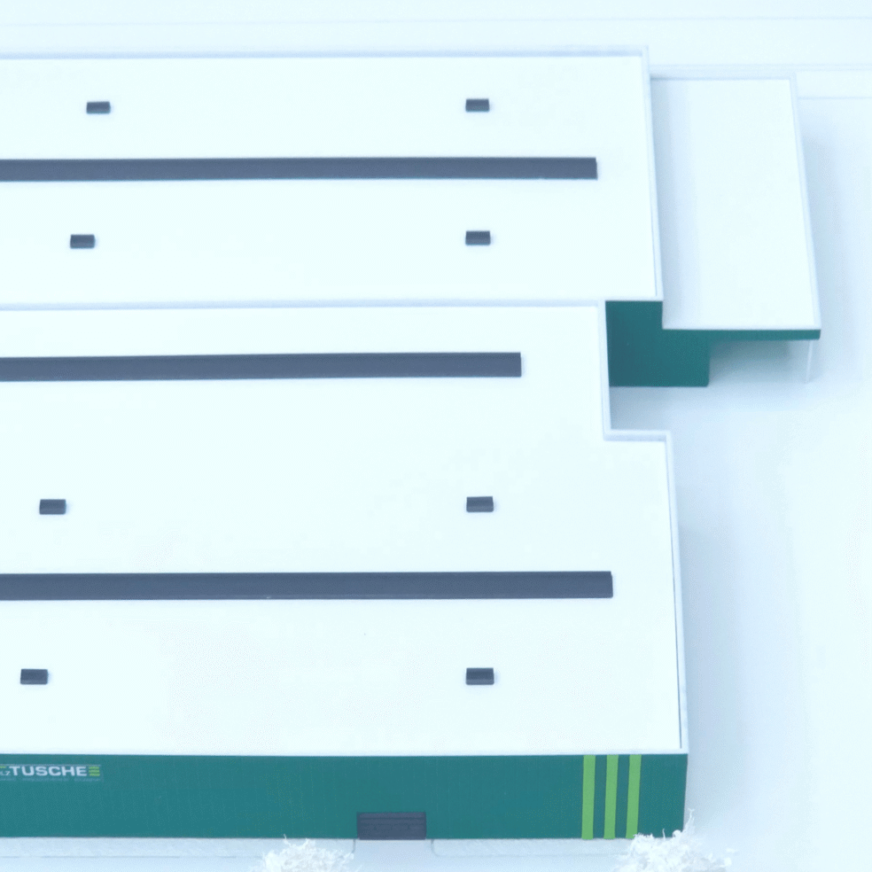 Übersicht des Kommunikationsmodells für das Holz Tusche Werk im Maßstab 1:500 mit Hallengebäude und Baumstruktur.