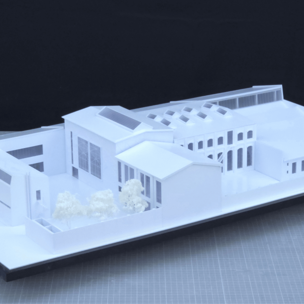 Schrägansicht des Altbaumodells für Atelier Röhm mit Hofseite, Hallengebäude und differenzierter Dachlandschaft.