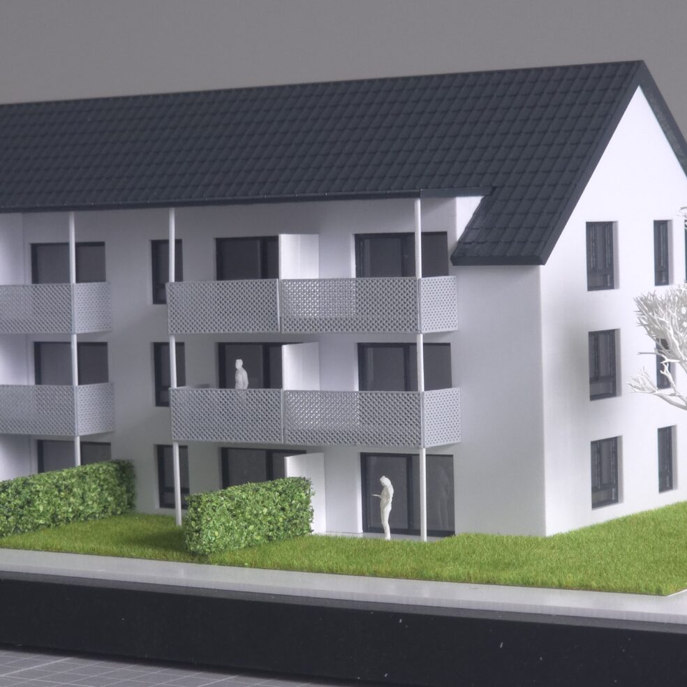 Gesamtüberblick Wohnbau-Modell 1:100: Entwurf detailliert, Nachbarbebauung neutral als Volumen.