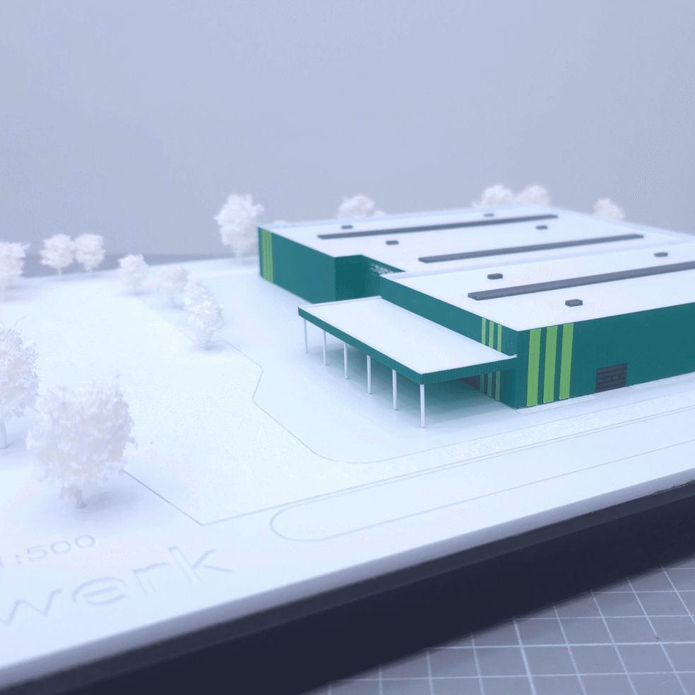 Schrägansicht des Werksmodells für Holz Tusche mit Gewerbebau, Eingangszone und CI-Farben.